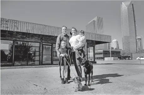  ?? [CHRIS LANDSBERGE­R PHOTOS/ THE OKLAHOMAN] ?? Tristan Young, left, and Shara Carlton enjoy a moment with their children Kadence and J.D. Young and dogs Fawn, center, and Alex at their new OKC Vet Campus opening next month at 601 W Reno Ave.