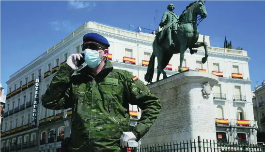  ?? CIPRIANO PASTRANO ?? Un militar habla por teléfono en la Puerta del Sol, donde está la sede del Gobierno regional