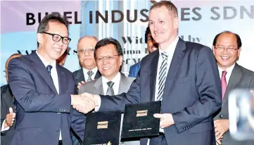  ??  ?? POIC Sabah chief executive officer Datuk Pang Teck Wai (left) shaking hands with Strategic Swiss Partners executive chairman Per N. Brantzag, who is Burel Industries financial advisor, and witnessed by Shafie and Madius.