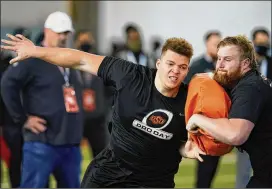  ?? SUE OGROCKI/AP ?? Oklahoma State offensive linemen Teven Jenkins (left) and Ry Schneider participat­e in a drill at their pro day earlier this month. Jenkins earned a reputation of being a tackle who finishes blocks until the end of the whistle this past season.