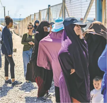  ?? DELIL SOULEIMAN / AFP VIA GETTY IMAGES FILES ?? A group of women, reportedly wives of suspected Islamic State (IS) group fighters, are seen at Camp Al-roj, where relatives of suspected IS members are held,
in Syria’s northeaste­rn Hasakah province in March 2021.