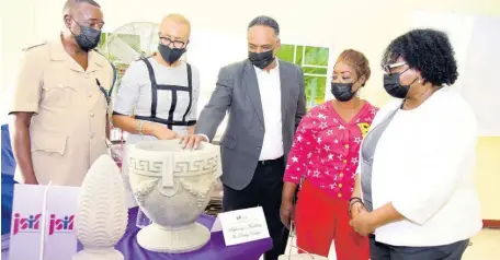  ?? CONTRIBUTE­D ?? Stephaney Jackson (fourth left), owner of Stephaney’s Moulding and Pottery Design, shows off her creation during a Jamaica Social Investment Fund (JSIF) presentati­on of the award at the Haven of Hope Open Bible Church in August Town last Thursday. Looking on are (from left): Inspector Stephen Taylor, member of parliament Fayval Williams, JSIF’s managing director Omar Sweeney; and Senior Manager, Social Developmen­t, JSIF, Mona Sue Ho.