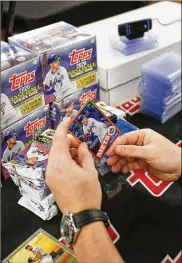  ?? BRANDON WADE / AP IMAGES FOR TOPPS ?? A collector finds a card of Pete Alonso, the face of the 2020 Topps Baseball Series One packaging, during the Topps Million Card Rip Party on Feb. 4 at AT&T Stadium in Arlington, Texas.