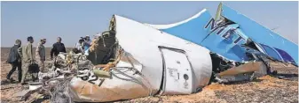  ?? MAXIM GRIGORIEV, RUSSIAN EMERGENCY MINISTRY/EPA ?? Russian Emergency Situations Minister Vladimir Puchkov, fourth from left, and others examine wreckage of MetroJet Airbus A321 in Sinai, Egypt.