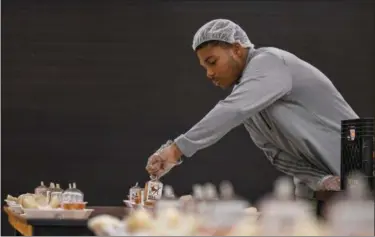  ?? ERIC BONZAR — THE MORNING JOURNAL ?? Lorain High School senior Ke’Andre Davis, 18, places containers of milk on to meal trays Feb. 7, during the Boys and Girls Clubs of Lorain County’s after school program at Frank Jacinto Elementary School.