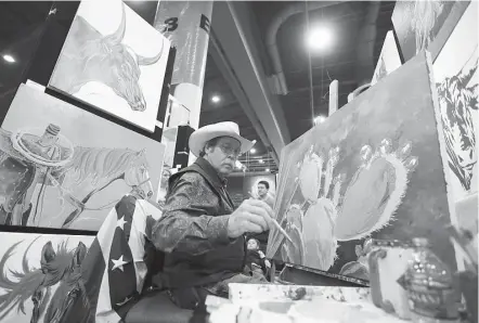  ?? Karen Warren / Houston Chronicle ?? Lyndon Gaither paints in his booth, as he sells his colorful Western-themed paintings at the Houston Livestock Show and Rodeo at NRG Center on Saturday.