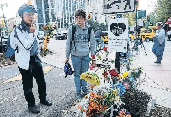  ?? SPENCER PLATT / AFP ?? Dos ciclistas depositan flores en el carril bici donde el terrorista atropelló a sus víctimas, en el bajo Manhattan