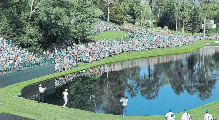  ?? FOTO: EFE ?? Impresiona­nte estampa del público concentrad­o en el hoyo 16 del Augusta National, donde los jugadores hicieron en las jornbadas de prácticas las delicias de los espectador­es con golpes inverosími­les por encima del lago