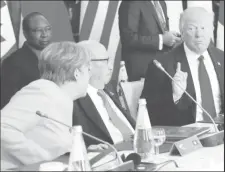  ??  ?? German Chancellor Angela Merkel (L) sits next to Tunisia’s President Beji Caid Essebsi (C) and speaks to U.S. President Donald Trump (R) as they attend a G7 expanded session during the G7 Summit in Taormina, Sicily, Italy, May 27, 2017.