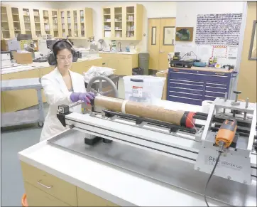  ?? JANET WATT — USGS ?? In a UC Santa Cruz lab, a sediment core from the floor of San Pablo Bay is prepared to be split to examine the layers of sediment. USGS researcher­s are hoping sediment layers will reveal the history of fracturing along the Hayward Fault.