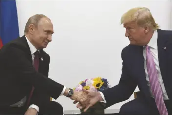  ?? ASSOCIATED PRESS ?? IN THIS JUNE 28, 2019, file photo President Donald Trump (right) shakes hands with Russian President Vladimir Putin (left) during a bilateral meeting on the sidelines of the G-20 summit in Osaka, Japan.