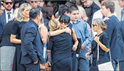  ?? CP PHOTO ?? People embrace after the funeral for 18-year-old Danforth shooting victim Reese Fallon in Toronto, Monday.