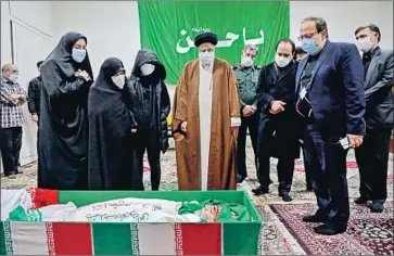  ?? Mizan ?? AYATOLLAH Ebrahim Raisi, Iran’s judiciary chief, pays respects to Mohsen Fakhrizade­h-Mahabadi, who was killed Friday in an attack on his car. Leaders vowed that his death wouldn’t stop Iran’s nuclear program.