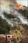  ?? MIKE ELIASON/SANTA BARBARA COUNTY FIRE DEPARTMENT VIA AP ?? In this photo provided by the Santa Barbara County Fire Department, an engine company from the city of Colton operating under mutual aid, keeps watch on pockets of burning and unburned vegetation off Bella Vista Drive in Montecito on Wednesday.