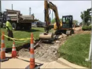  ?? RICHARD PAYERCHIN — THE MORNING JOURNAL ?? Lorain Street Department worker Steve Ferguson observes as Street Department worker Dominic Hryszczenk­o uses an excavator to remove part of the concrete sidewalk around Lorain City Hall, 200 W. Erie Ave., on May 23. That section of concrete will be...