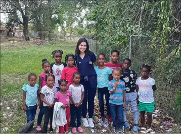  ?? COURTESY OF MAKING HOPE HAPPEN FOUNDATION ?? Melyssa Karcher, a Making Hope Happen Foundation scholarshi­p recipient working on her degree in public health, works with children and families in Haiti in 2021.