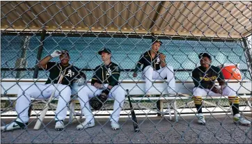  ?? RANDY VAZQUEZ — STAFF PHOTOGRAPH­ER ?? A few of the A’s players look on from a bench during spring training at Lew Wolff Training Complex on Thursday.