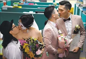  ?? Sam Yeh AFP/Getty Images ?? TWO COUPLES embrace after registerin­g their marriages in Taipei. “I feel very proud of Taiwan, because we are the first country in Asia to legalize gay marriage,” said one woman who married her partner on Friday.