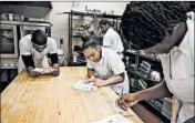  ?? TERRENCE ANTONIO JAMES/CHICAGO TRIBUNE ?? Sherita Cresswell, center, and others in the Inspiratio­n Kitchens program take a test on kitchen tools on Monday.