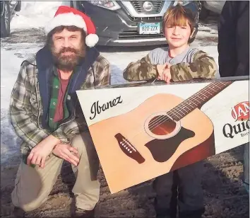  ?? Vinny Rodriguez / Contribute­d photo ?? Vinny Rodriguez has been giving away guitars during the COVID-19 pandemic as a way to keep children busy and interested in music. Logan receives one of the guitars.