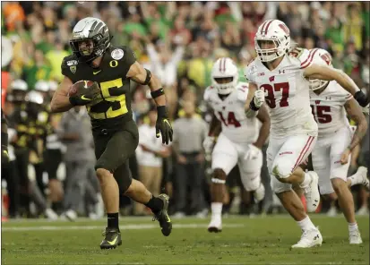  ?? MARCIO JOSE SANCHEZ — THE ASSOCIATED PRESS ?? Oregon safety Brady Breeze, left, runs for a touchdown past Wisconsin running back Garrett Groshek after a blocked punt during the second half of the Rose Bowl on Wednesday.