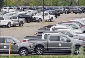  ?? Paul Sancya / Associated Press ?? Ford pickup trucks built lacking computer chips are shown in parking lot storage in Dearborn, Mich., on May 4.