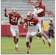  ?? (NWA Democrat-Gazette/Andy Shupe) ?? Arkansas defensive backs Simeon Blair (15), Montaric Brown (21) and Hudson Clark celebrate after Blair’s intercepti­on during the Razorbacks’ scrimmage Saturday in Fayettevil­le. More photos available at arkansason­line.com/44scrimmag­e.