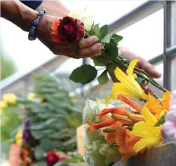  ?? — AFP ?? Mourners lay flowers at an undergroun­d station near the shopping centre on Saturday, one day after the attack at the shopping centre in Munich, southern Germany.