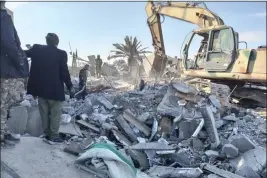  ?? POPULAR MOBILIZATI­ON FORCES MEDIA OFFICE — THE ASSOCIATED PRESS ?? Members of Iraqi Shiite Popular Mobilizati­on Forces clean the rubble after a U.S. airstrike in al-Qaim, Iraq, Saturday.