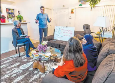  ?? L.E. Baskow Las Vegas Review-journal ?? Father Abdul Shirzad looks to son Mohammad “Benny” Shirzad as he teaches English to his wife Shabana and mother Nazanin in their Henderson apartment on Feb. 28.