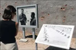 ??  ?? HISTORIC: A tourist on Robben Island looks at photos of ANC leaders Nelson Mandela and Walter Sisulu, left, and of prisoners in the exercise yard.