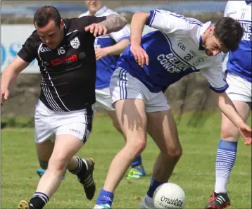  ??  ?? Rival substitute­s John Bergin (St. Joseph’s) and Kevin Ring (Ballyhogue) tussle for the ball.