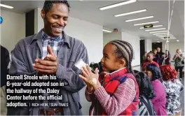  ??  ?? Darnell Steele with his 6- year- old adopted son in the hallway of the Daley Center before the official adoption.