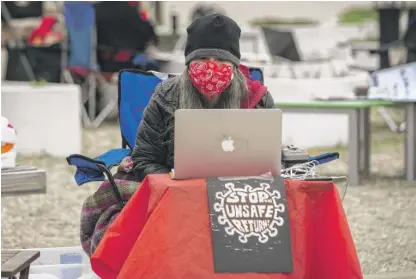  ?? ASHLEE REZIN GARCIA/SUN-TIMES ?? Liz Winfield, an art and yearbook teacher at Benito Juarez High School, joins other Chicago Teachers Union educators Thursday morning in teaching remotely outside the Southwest Side school.