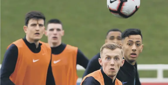  ??  ?? James Ward-Prowse (second right) keeps his eyes on the ball at training yesterday.