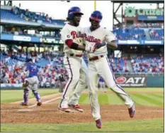  ?? DERIK HAMILTON - THE ASSOCIATED PRESS ?? The Phillies’ Nick Williams, right, leaps into the arms of Odubel Herrera after hitting a three-run inside-the-park home run off the New York Mets’ Rafael Montero during the eighth inning Sunday in Philadelph­ia.