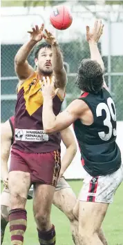  ??  ?? Drouin’s Bob McCallum’s experience shone through as he controlled the ruck contests against Maffra, generally outpositio­ning opponents and, as shown above, where possible deciding that two hands were better than one in the slippery going.