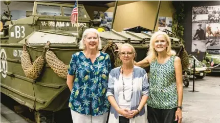  ?? CONNOLLY/ORLANDO SENTINEL PATRICK ?? Sisters Beth Stoor, left, and Leslie Holland, right, along with Lisa Keith-Lucas, center, a museum archivist, stand in front of a DUKW“duck”amphibious vehicle that was part of their father’s 818th Amphibious Truck Company in the Orlando Auto Museum at Dezerland Action Park on Tuesday.