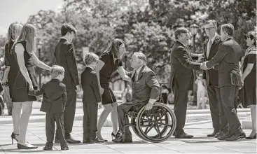  ?? Tamir Kalifa / Austin American-Statesman ?? Gov. Greg Abbott, center, Lt. Gov. Dan Patrick, third from right, and House Speaker Joe Straus, second from right, greet relatives of Mark White, as the former governor’s casket is moved into the Capitol in Austin.