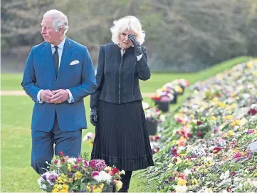  ??  ?? BLANKET OF FLOWERS: Prince Charles and Camilla at the Marlboroug­h House tribute.