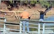  ?? Doug Walker / Rome News-Tribune ?? Auburn veterinari­an Dr. Seth Oster (left) watches as Rachel Womack releases a juvenile bald eagle Saturday at Lake Allatoona.