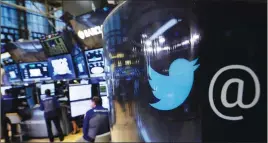  ?? AP PHOTO ?? The Twitter logo appears on a phone post on the floor of the New York Stock Exchange.