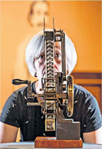  ??  ?? Toni Booth, a curator at the National Science and Media Museum in Bradford, with film equipment dating from 1896, part of the museum’s new exhibition The Forgotten Showman, looking at the life and work of Robert Paul, an early pioneer of the medium.