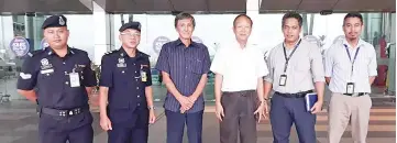  ??  ?? Hiew and Lu Chew Seng with the airport maintenanc­e staff and security officers.