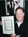  ??  ?? Danny Filippone hoists a B.C. Entertainm­ent Hall of Fame award in front of a photo of his dad with Joe Philliponi and Johnnie Ray.