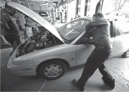  ??  ?? ABOVE: Mechanics Chris Geropoulos, right, and David Galvin work on a car on July 5, at Ted’s Auto Clinic in Chicago. In looking for a mechanic, experts say it’s a good idea to establish a relationsh­ip and find a repair shop you can trust, or you may...