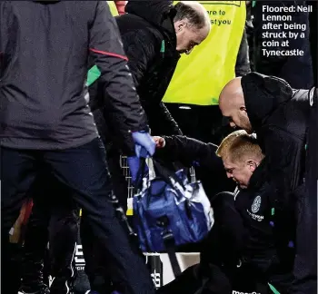  ??  ?? Floored: Neil Lennon after being struck by a coin at Tynecastle