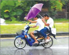  ??  ?? JUST APPRECIATE THE HUMOUR . . . Drive fast on a wet road, with no helmet, often with one hand only, the other hand is holding an umbrella against the wind. Anyway, with the rain in your face, you can’t really open your eyes, can you?