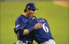  ?? JEFF GROSS / GETTY IMAGES ?? Milwaukee Brewers outfielder Christian Yelich (with teammate Lorenzo Cain) nearly won the Triple Crown, but he came up short on the final day of the season. He’ll likely have to console himself with the NL MVP award.