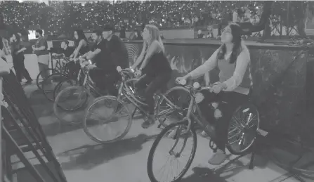  ?? INVISION/AP ?? Concertgoe­rs ride stationary bikes during Coldplay’s tour in Glendale, Ariz. The band has included energy-storing bikes to their tour, encouragin­g fans to help power the show to make the tour more environmen­tally friendly.